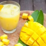 Mango juice, smoothie and mango fruit on a wooden background